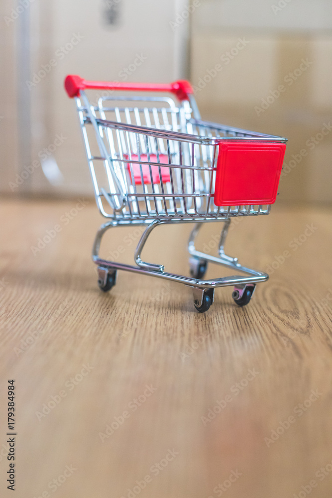 Mini Einkaufswagen mit Paketen im Hintergrund, Onlineshopping Mini Einkaufswagen mit Paketen im Hintergrund, Onlineshopping