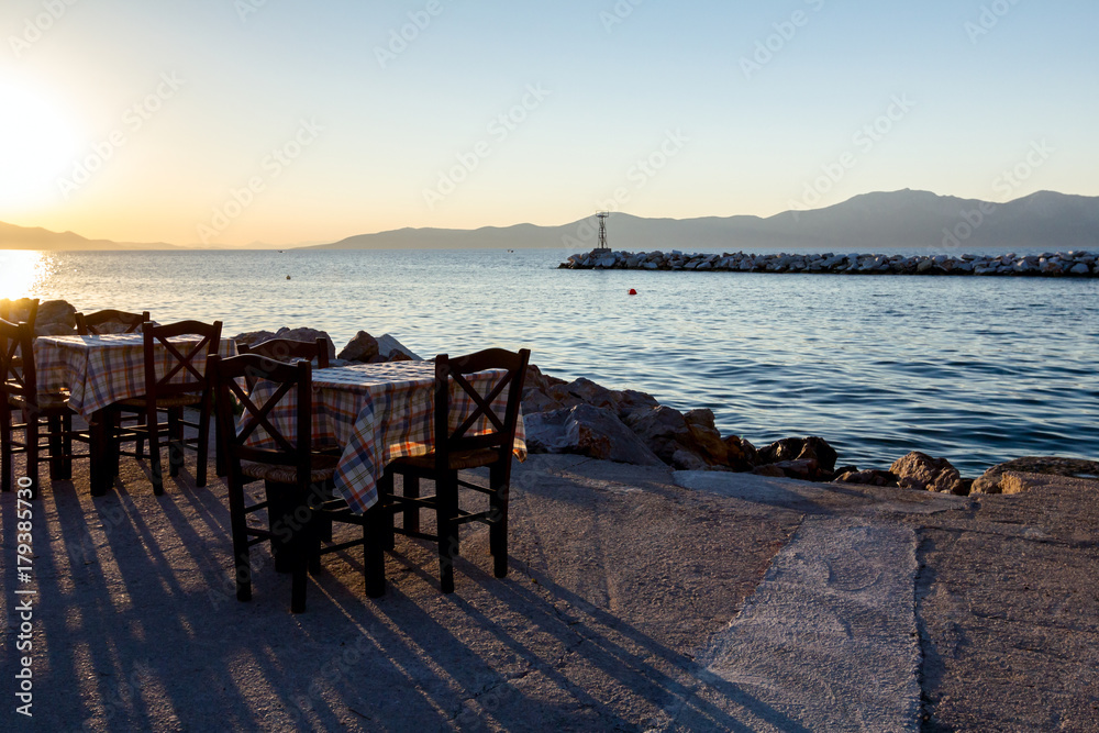 Evening at traditional Greek tavern, restaurant by the open sea Evening at traditional Greek tavern, restaurant by the open sea