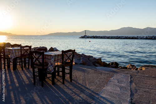 Evening at traditional Greek tavern, restaurant by the open sea © Roman_23203