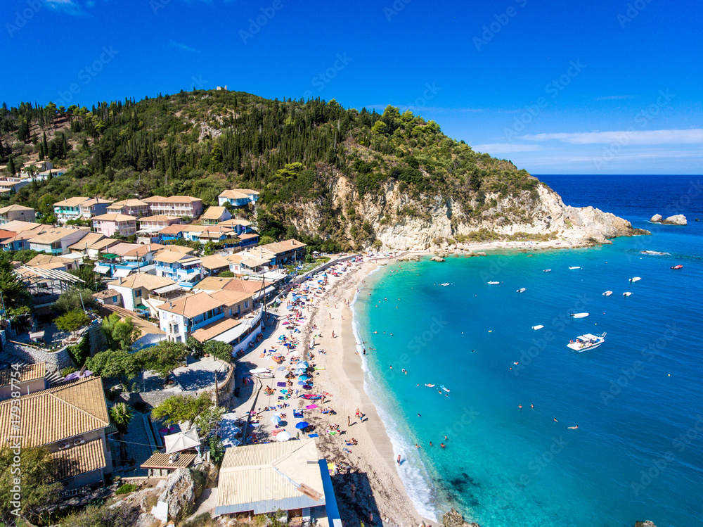 Lefkada Agios Nikitas Beach with tourists on the sandy beach and clear blue waters in the summer