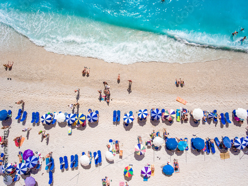 Aerial view of Egremni Beach Lefkada with tourists relaxing on the beach, swimming and playing games on a hot summer day