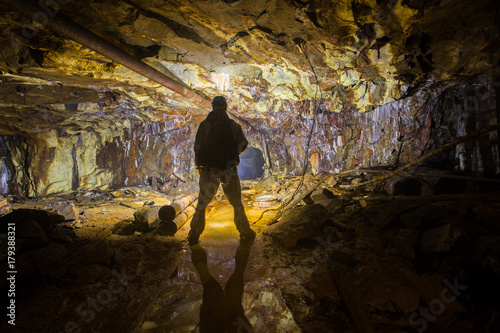 Miner explorer in the dark tunnel gallery ore shaft mine