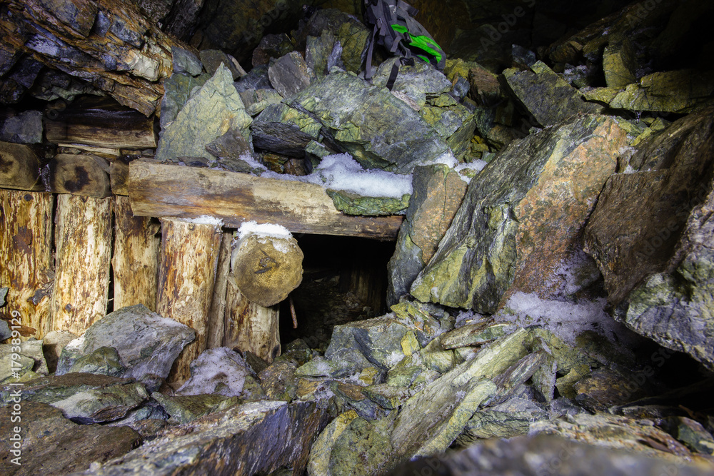 Fototapeta premium Abandoned old chromite mine shaft tunnel with wooden timbering
