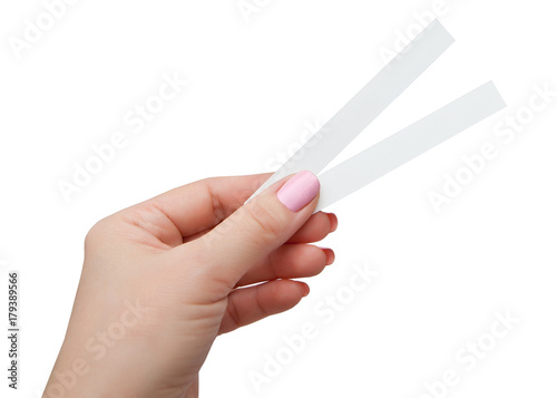 Female hand with two paper test strips for the perfume, isolated on white background