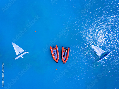 Yachts and resque speed boats ancored in clear blue sea photo