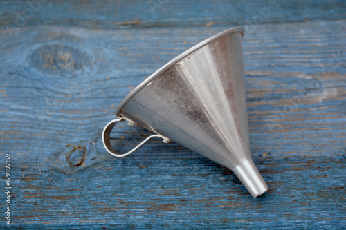 Vintage metal funnel with handle on old wooden  table