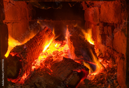 Logs burning in ancient peasant masonry oven in Ukraine