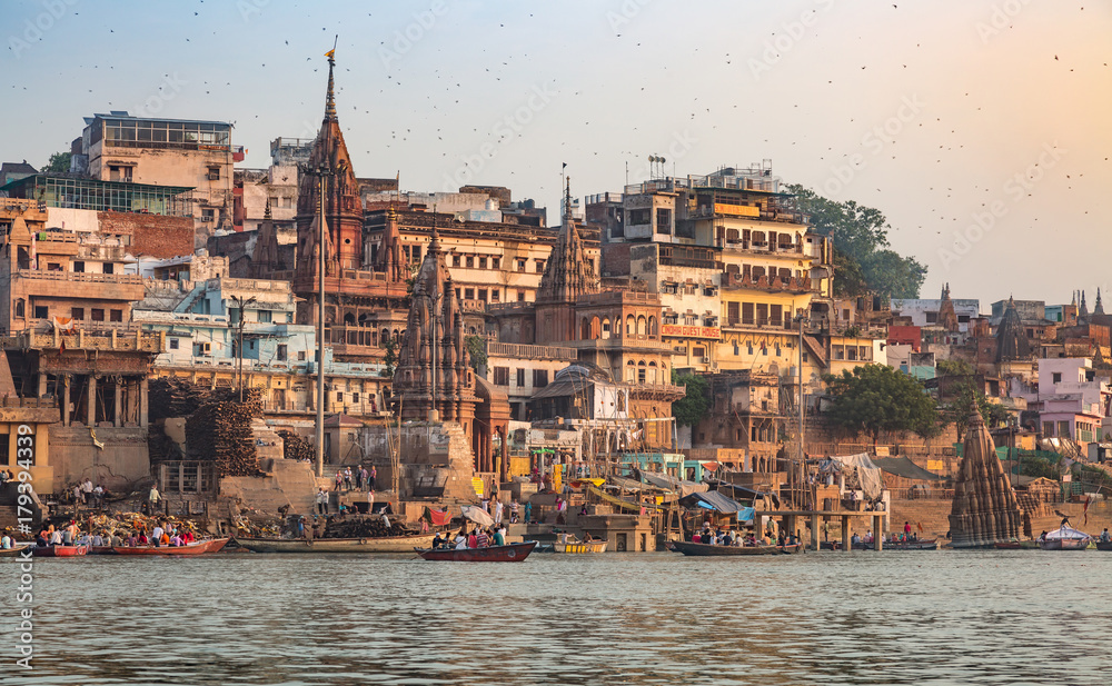 Varanasi Ganges river ghat with old architectural buildings and ancient temples as viewed from a boat at sunrise