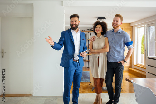 Young couple looking new home with agent photo