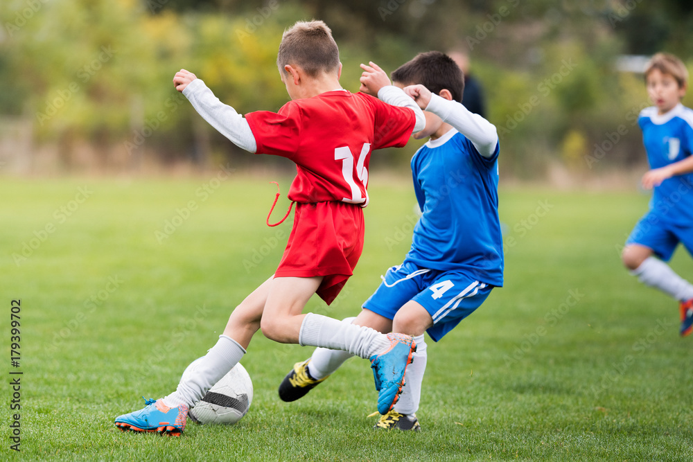 Naklejka premium Young children players football match on soccer field