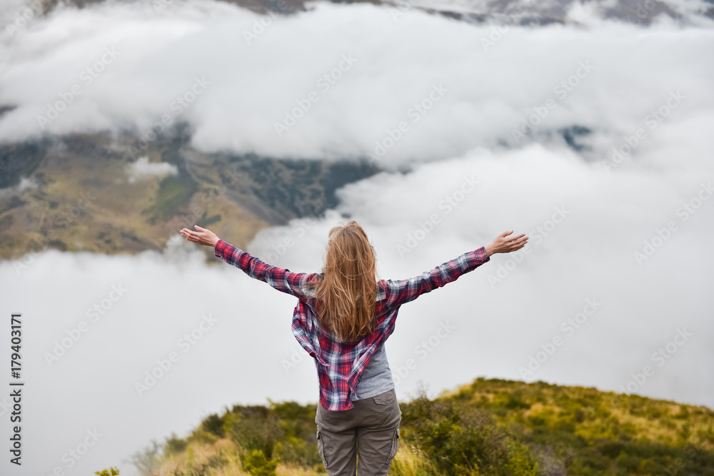 Happy young traveler woman walking in the mountain with long bright streaming hair. Feeling success, freedom and happiness. Amazing clouds in New Zealand Happy young traveler woman walking in the mountain with long bright streaming hair. Feeling success, freedom and happiness. Amazing clouds in New Zealand