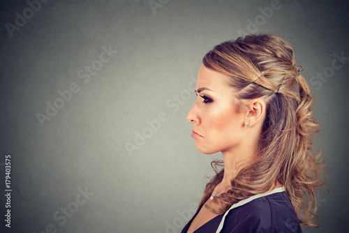 Side profile of a grumpy annoyed dissatisfied young woman