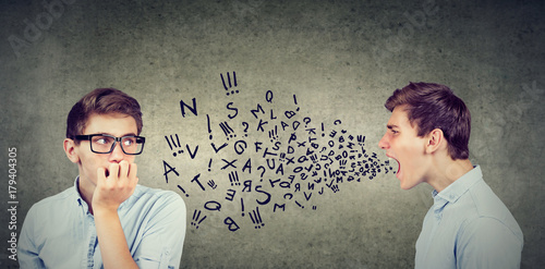 Split personality. Angry young man screaming at scared anxious himself photo