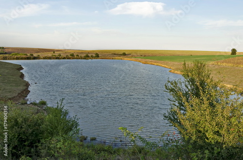 Picturesque landscape with view of the lake in a autumnal field in Ludogorie area, Zavet, Bulgaria  photo