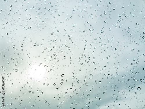 Photograph of raindrop on clear glass close up.