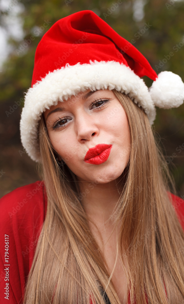 Young woman with Christmas hat in the forest Young woman with Christmas hat in the forest