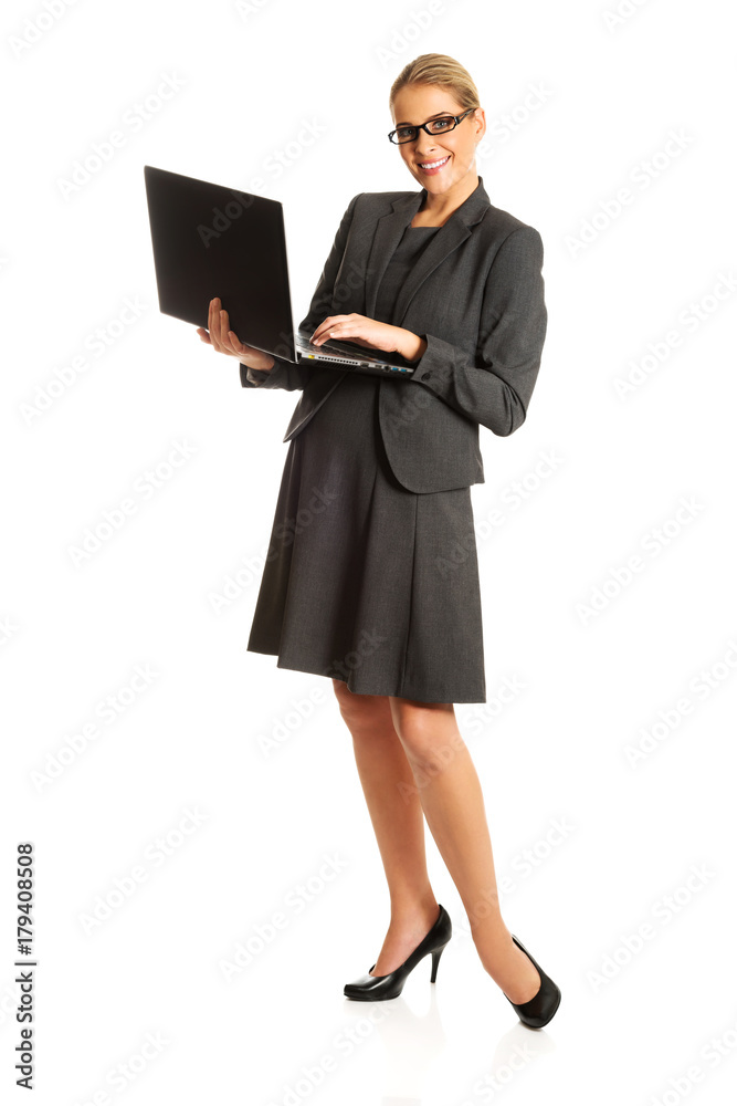 Businesswoman standing and holding a laptop
