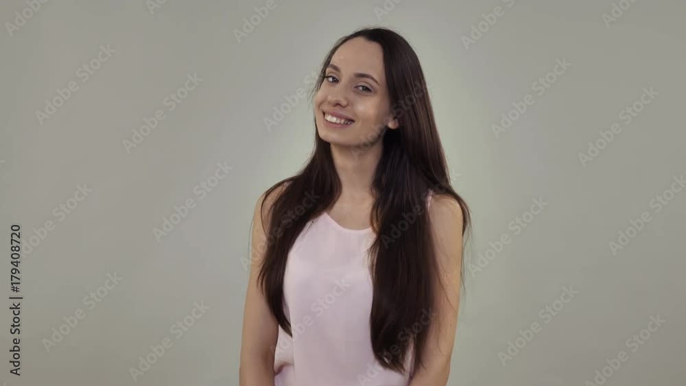 Portrait attractive smiling woman posing looking at the camera with happy smile. Young caucasian model with beautiful long hair in studio Portrait attractive smiling woman posing looking at the camera with happy smile. Young caucasian model with beautiful long hair in studio