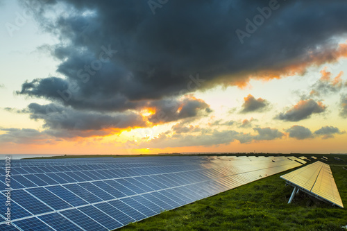 Solar panels at sunrise with cloudy sky in Normandy  France. Solar energy  modern electric power production technology  renewable energy concept. Environmentally friendly electricity production