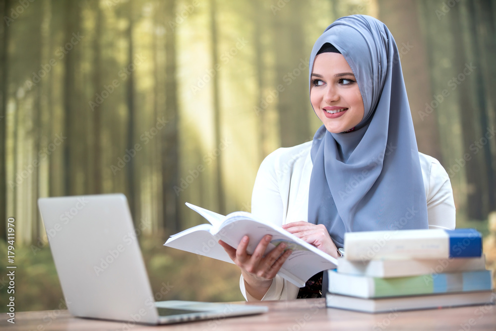 Pretty woman wearing hijab in front of laptop