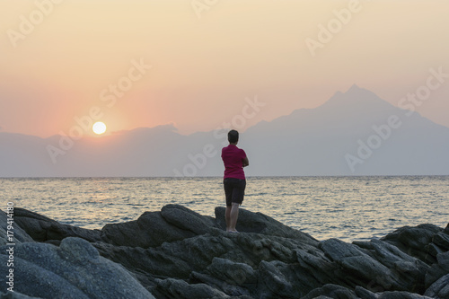 Woman watching sunrise on the beach