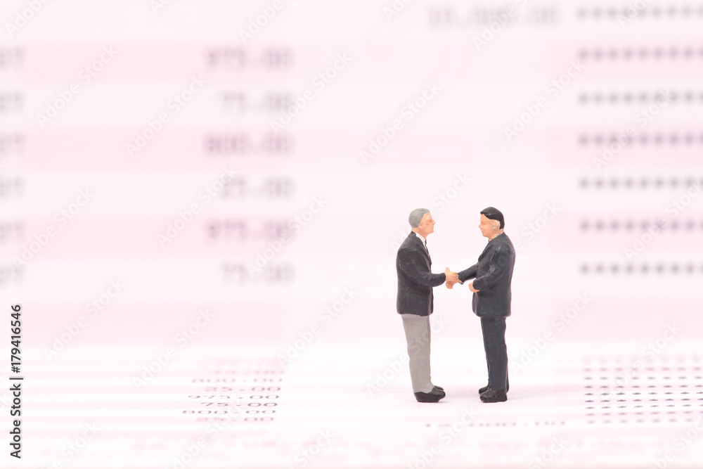 miniature people on business data and shaking hand,business concept miniature people on business data and shaking hand,business concept
