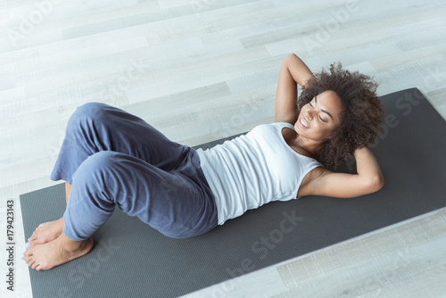 Happy woman making abs exercises at home