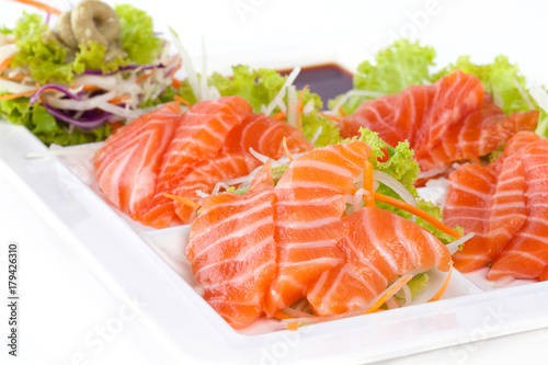 raw salmon with wasabi and sauce isolated on white plate on white background