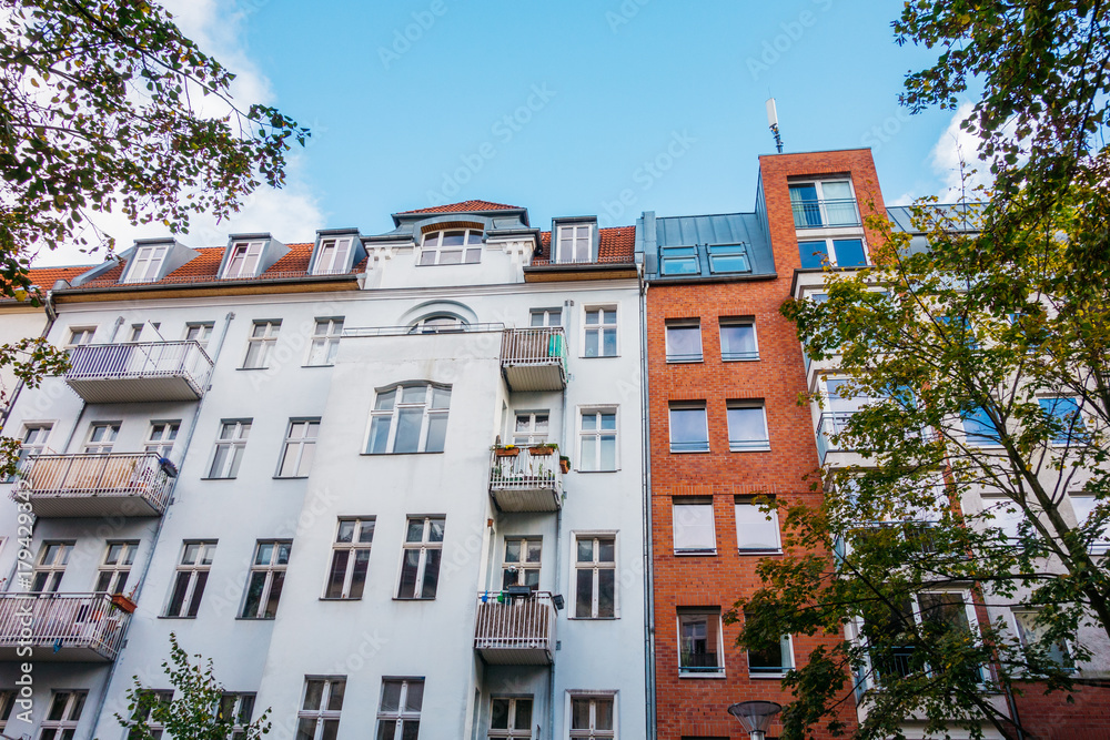 old and modern apartment house at berlin with white and red facade