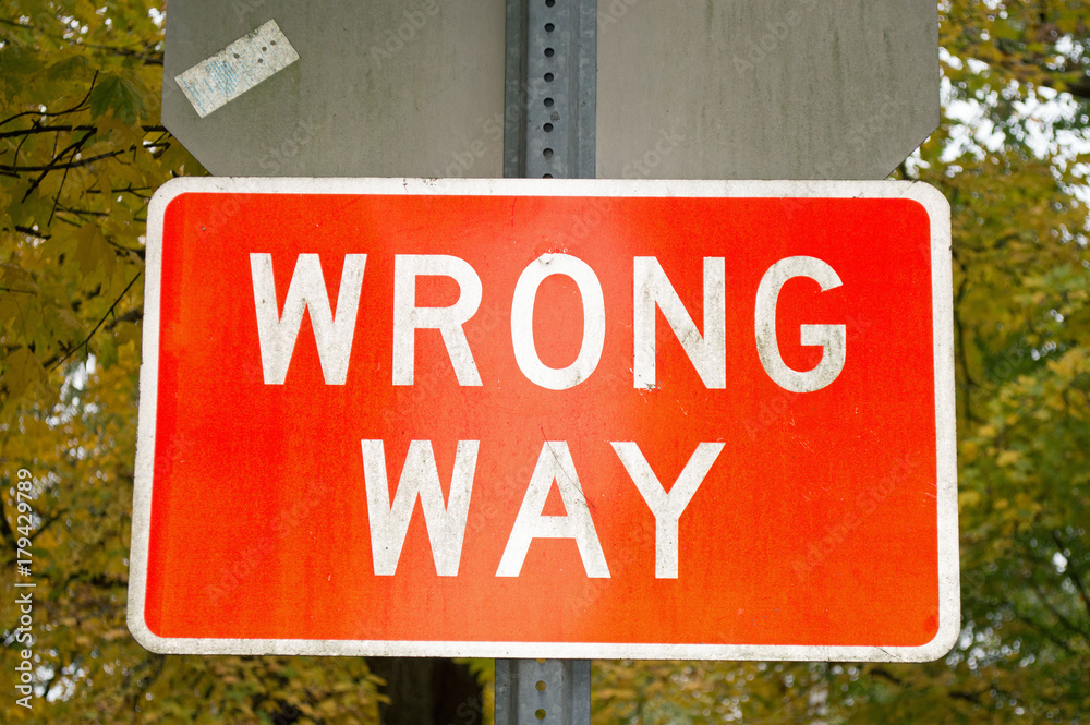 Photo of a red, rectangular sign warning drivers that this is the wrong way to go