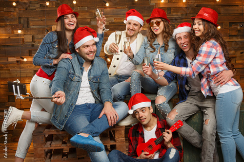Party with group friends wearing Santa s hats. Young people  hipsters sharing good and positive mood  celebrate special occasion. Midnight at New Year s Eve party or christmas.