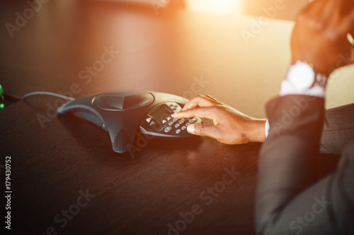 Foto Attractive Afro-American young businessman on conference ip phone in office
