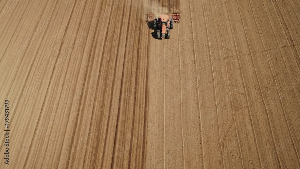 Drone aerial shot of a farmer cultivating arable field Drone aerial shot of a farmer cultivating arable field