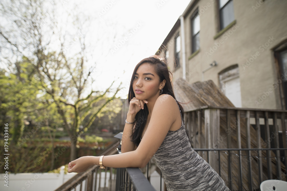 Portrait of young woman leaning on balcony railing Portrait of young woman leaning on balcony railing