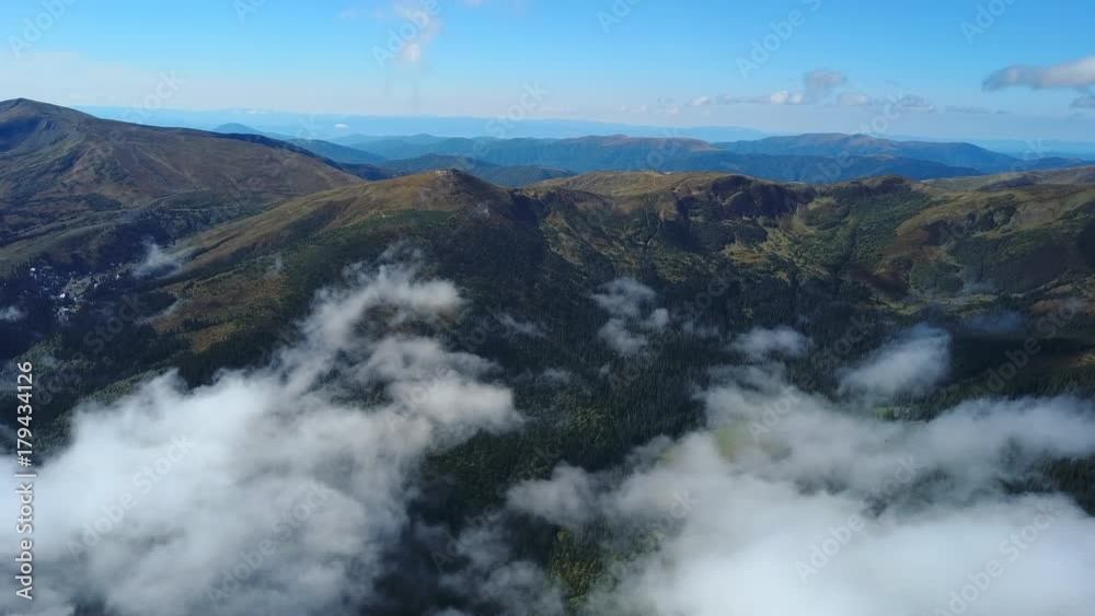 High altitude. Flying above mountains and misty clouds in the morning. Beautiful landscape of Carpathian mountains - Aerial view High altitude. Flying above mountains and misty clouds in the morning. Beautiful landscape of Carpathian mountains - Aerial view