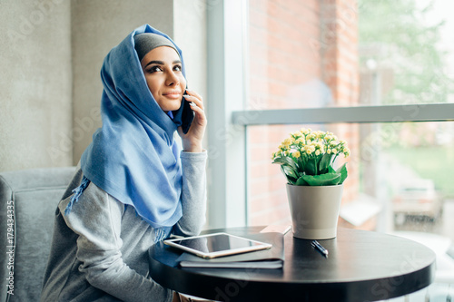 Successful Arab woman. Arab businesswoman wearing hijab talking on cell phone photo