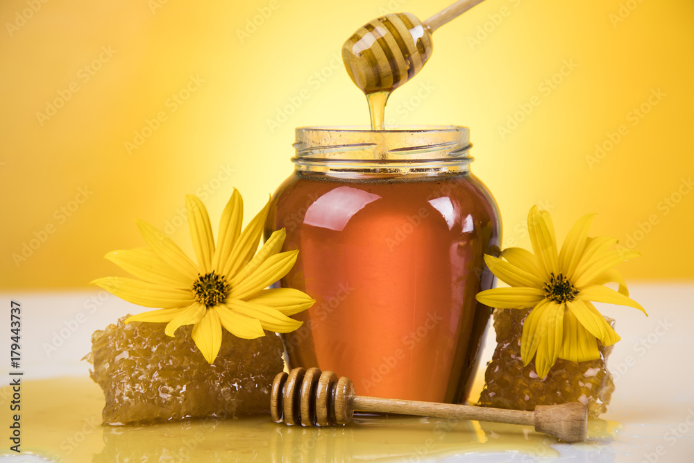 Honey jar, flower with dipper and flowing honey Honey jar, flower with dipper and flowing honey