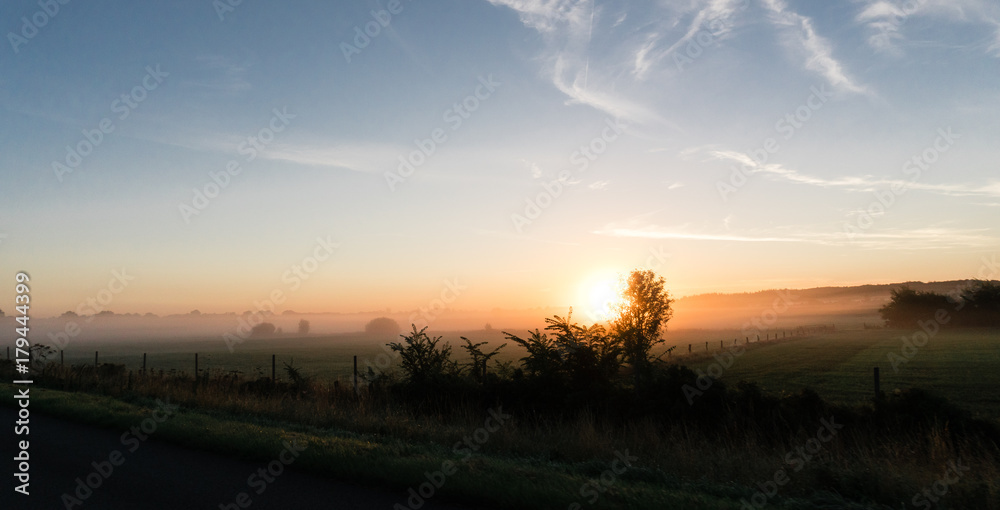 sunrise over a field in denmark photographed from the highway