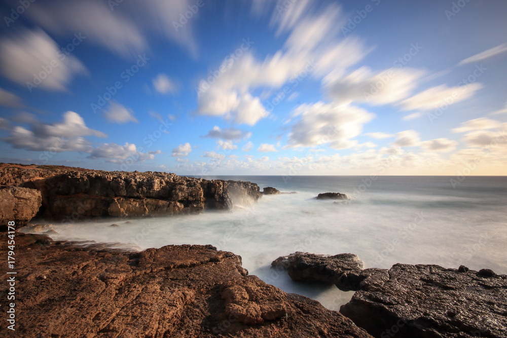 Fototapeta premium Long exposure from rocks and sea in the Portuguese coastline with the clouds moving