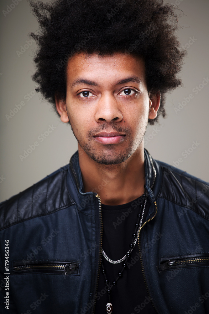 Fototapeta premium man with bushy curly hair blinking his eye having warm broad smile