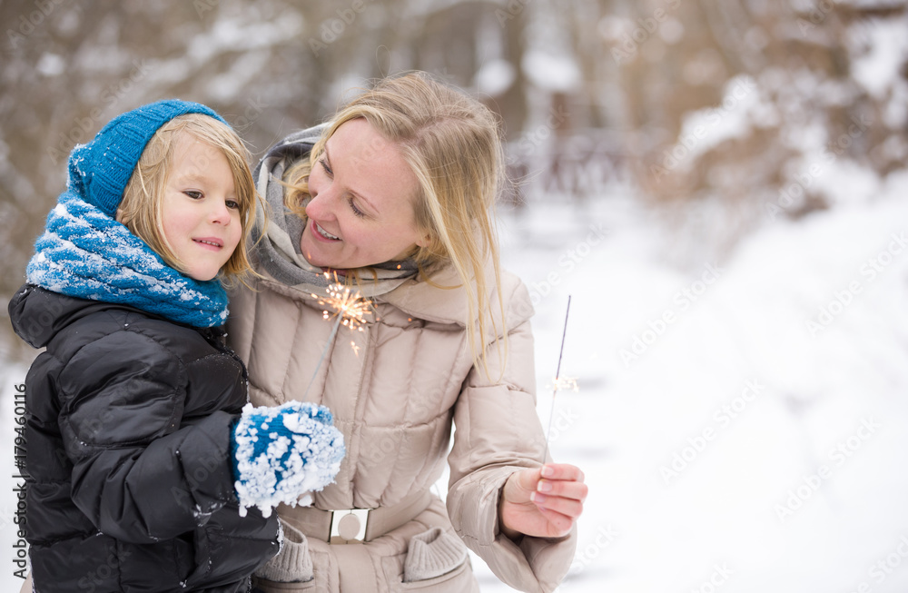 Φωτογραφία Portrait of happy mother and son burning sparklers outdoors in the park