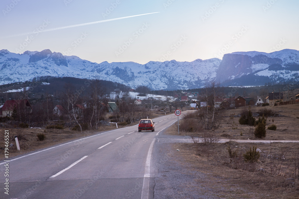 car rides on road to snow-covered mountain in sunny day car rides on road to snow-covered mountain in sunny day