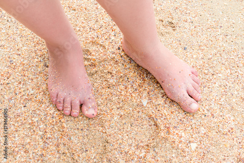 female legs on the sand on the beach view from above © kosmos111