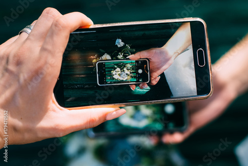 A hand holding a modern generic mobile phone which displays photo 