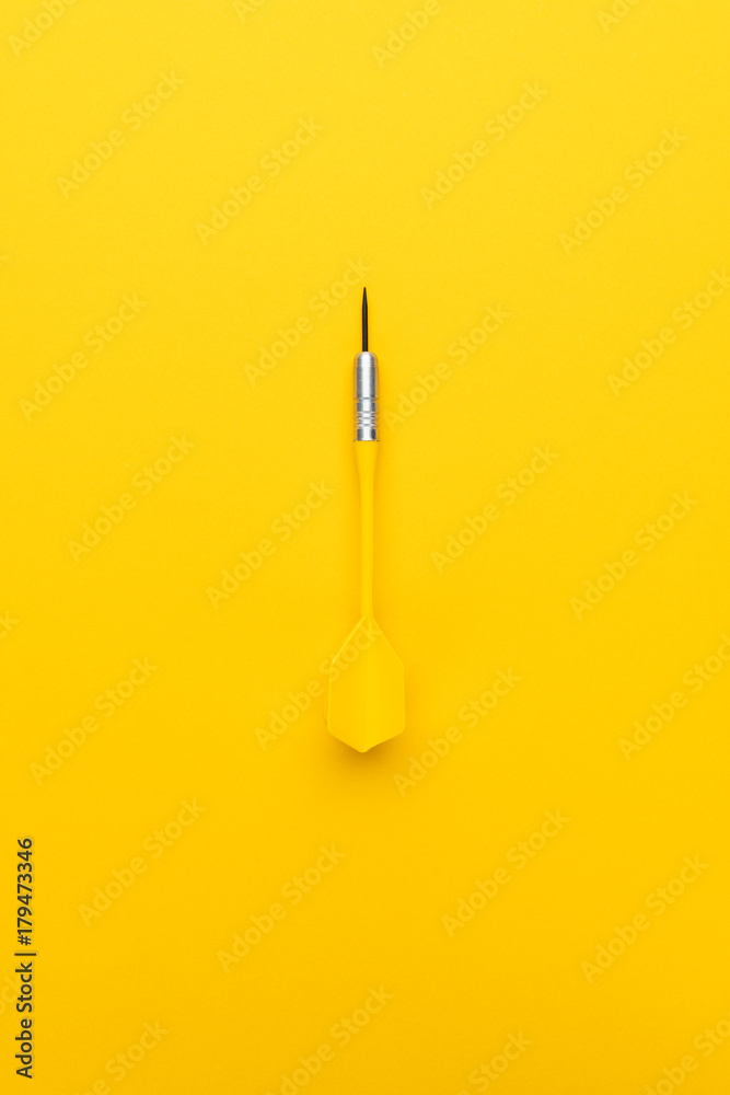 plastic dart with metal tip on the yellow background plastic dart with metal tip on the yellow background