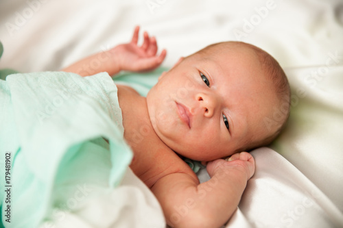 Newborn child lying on bed