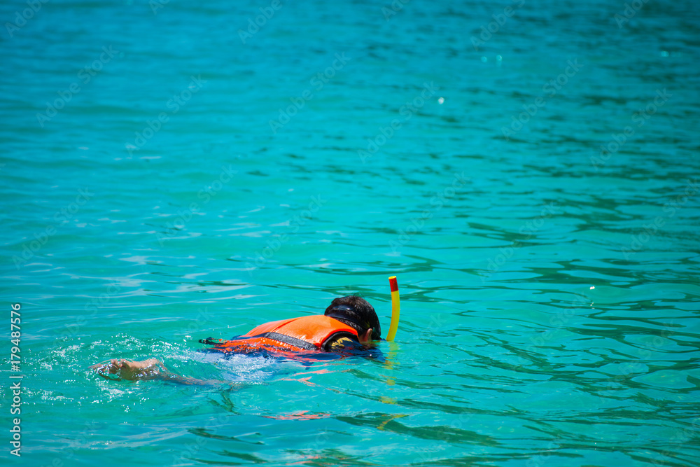 A man is a snorkeling in the tropical sea