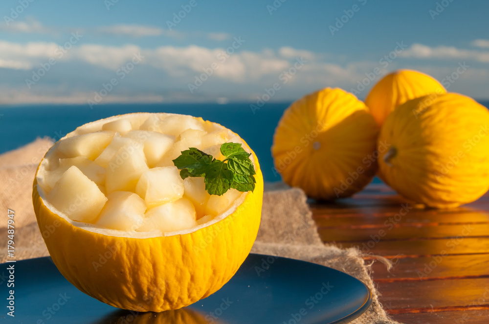 Φωτογραφία Typical mediterranean fruits: yellow melon with blue sea in the background