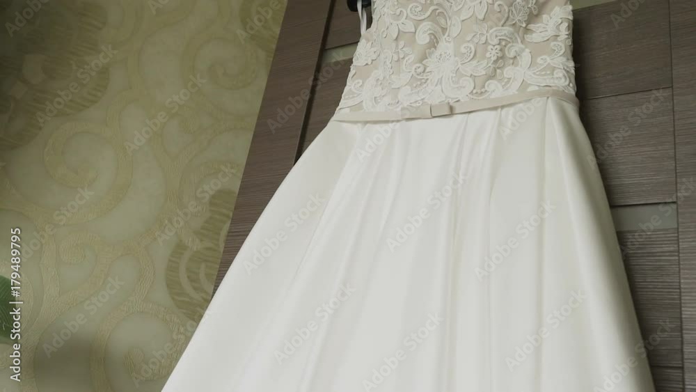 Wedding dress hanging in a white beautiful room Wedding dress hanging in a white beautiful room