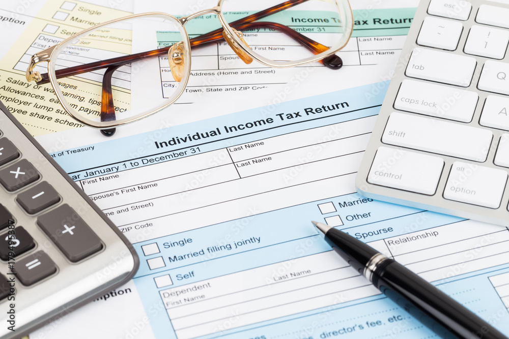 Tax form with calculator, glasses, keyboard, and pen; document are mock-up Tax form with calculator, glasses, keyboard, and pen; document are mock-up